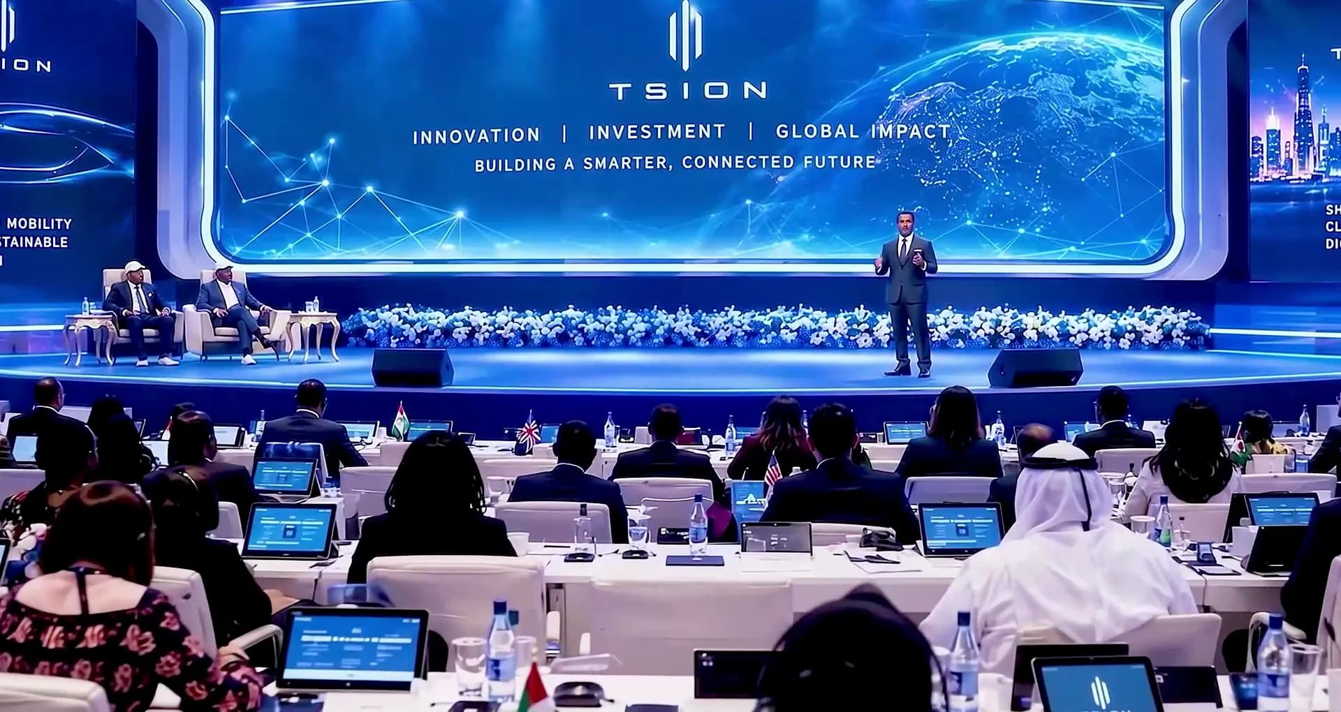 A presenter on the Tsion stage addressing an audience seated at tables